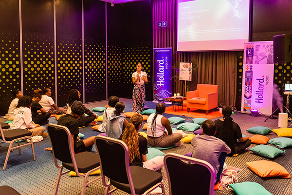 Hollard Health Wellness Day guests sitting on pillows, meditating